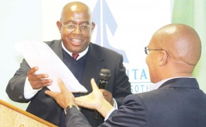 Lefa president Salemane Phafane (left) hands over the money to Likuena Manager Khiba Mohoanyane on Wednesday.