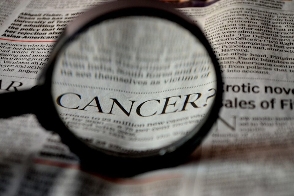 Pink breast cancer awareness ribbon on a pale background
